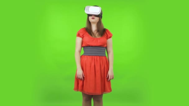 Linda chica con auriculares de realidad virtual o gafas 3D. Pantalla verde — Vídeos de Stock