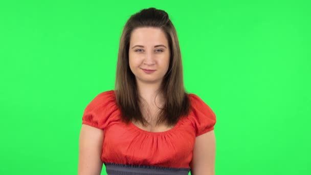 Portrait of cute girl coquettishly smiling while looking at camera. Green screen — Stock Video