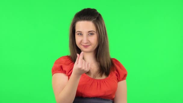 Sevimli bir kızın portresi gülümsüyor ve parmaklarıyla kalbini gösteriyor sonra da öpücük yolluyor. Yeşil Ekran — Stok video