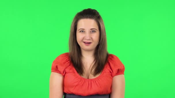 Portrait of cute girl is listening attentively and nodding her head pointing finger at viewer. Green screen — Stock Video