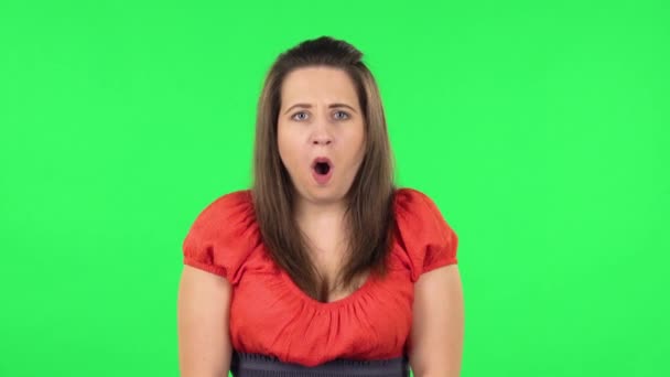 Portrait of girl carefully examines something then fearfully covers her face with her hands. Green screen — Stock Video