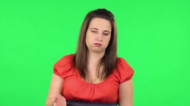 Portrait of cute girl cooling herself by her hand, suffering from high temperature weather. Green screen