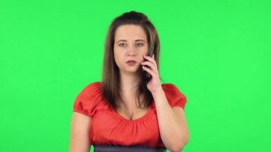 Portrait of cute girl talking for mobile phone, very shocked then rejoice. Green screen