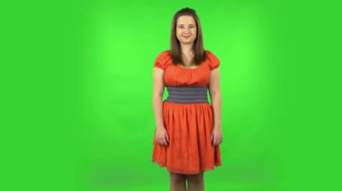 Cute girl smiling while looking at camera. Green screen