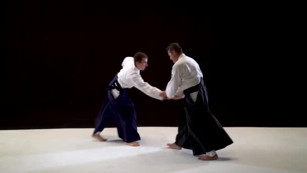 Siyah beyaz stüdyo üzerinde iki Aikido Masters tekniği tanıtımı. — Stok video