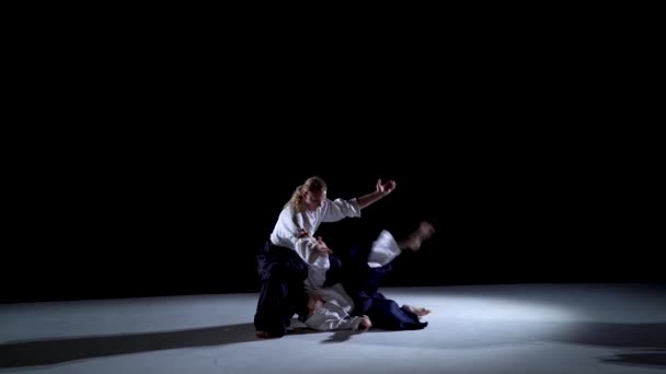 Twee Aikido Masters deelnemers aan de training in speciale kleding van aikido hakama werken de methoden van single combat uit. — Stockvideo