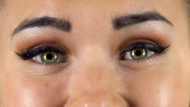 Green female eyes looking straight and smiling. Close up — Stockvideo