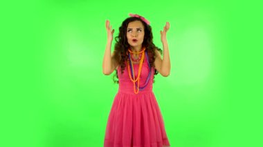 Lovely girl tells something then making a hush gesture, secret. Green screen at studio