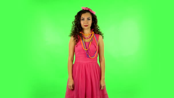 Pretty girl looks into the camera and then pulls her hands in front and having fun. Green screen — Stock videók