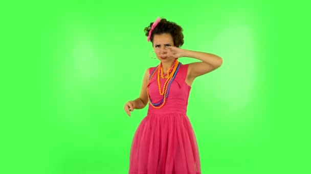 Lovely girl funny dances, poses for camera makes funny faces on green screen at studio. — Stok video