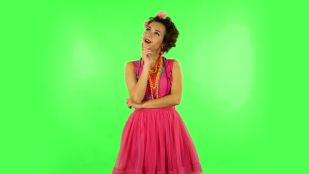 Lovely girl daydreaming and smiling looking up against green screen — Stock Video