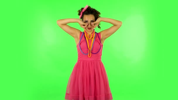 Модная девушка позирует для камеры делает смешные лица на зеленом экране в студии . — стоковое видео