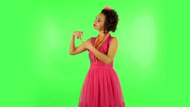 Vrouw wijst zijhand voor iets en toont duim als dan knikt afkeurend. Groen scherm — Stockvideo