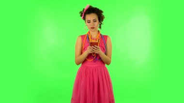 Young woman texting on her phone on green screen
