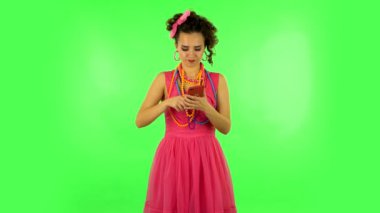 Young woman angrily texting on her phone on green screen
