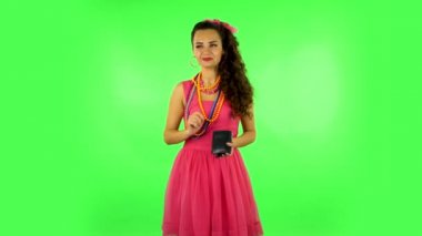 Upset woman shaking her wallet in search for money, then takes out a credit card and rejoicing. Green screen