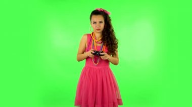 Girl playing a video game using a wireless controller and loses. Green screen