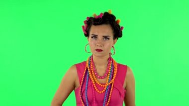 Girl with a rolling pin in her hands angry looks at the camera. Green screen