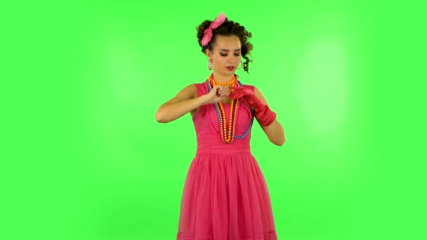 Attractive girl takes off her gloves and throws nearby on green screen — Stok video