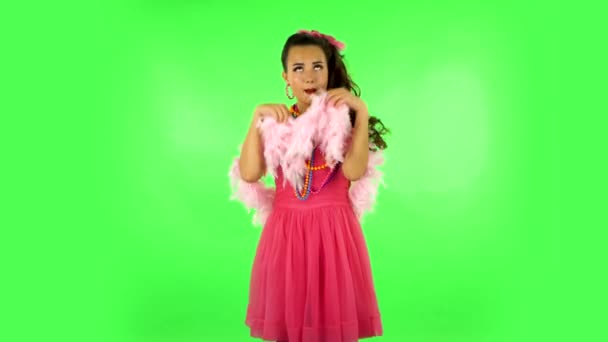 Menina dançando, sedutoramente sorrindo e posando com penas rosa. Tela verde — Vídeo de Stock