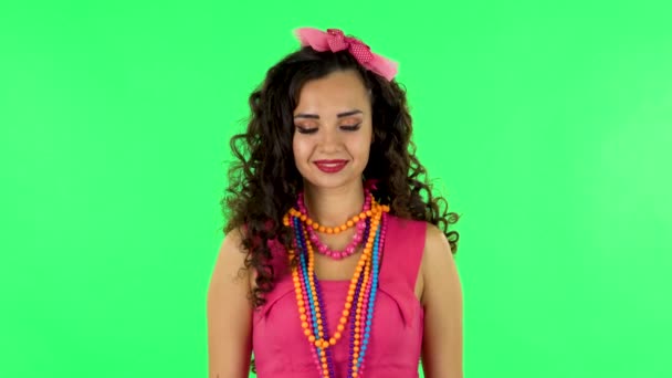 Pretty woman coquettishly smiling while looking at camera. Green screen — Stock video