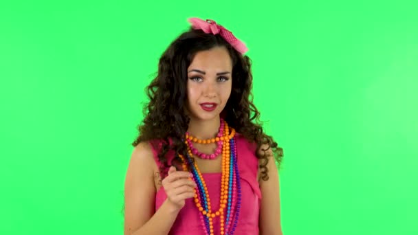 Curly girl flirts and waving hand, showing gesture come here. Green screen at studio — Wideo stockowe