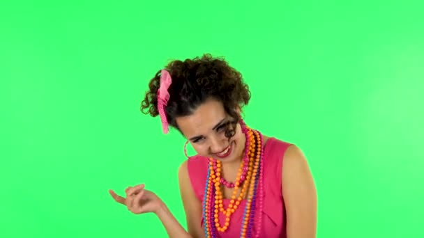 Pijana kobieta śmieje się i mówi coś przeciwko zielonemu ekranowi w studio. — Wideo stockowe