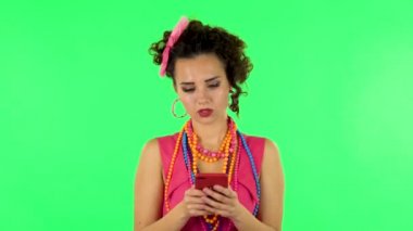 Young woman texting on her phone on green screen