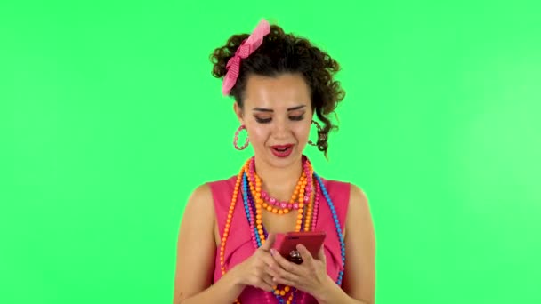 Jeune femme souriante texter sur son téléphone sur l'écran vert — Video