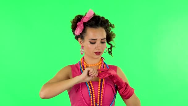 Girl takes off her gloves and throws nearby on green screen — Stockvideo