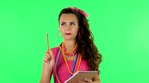 Girl stands and thinks, then writes with pencil in notebook and gets angry. Green screen — Stok video