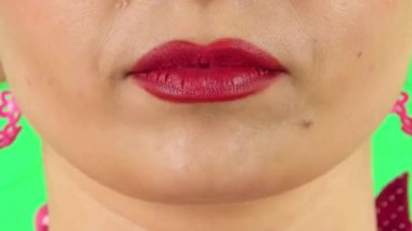 Young woman with red lips grimacing with showing tongue. Close up