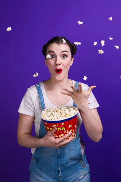 Emotionele wow vrouw gooien popcorn op blauwe achtergrond — Stockfoto