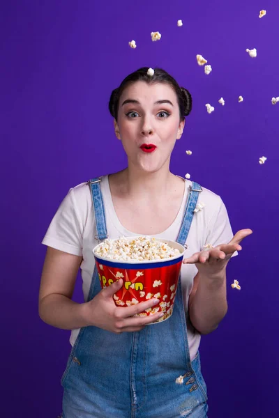 Emotionele wow meisje gooien popcorn op blauwe achtergrond — Stockfoto