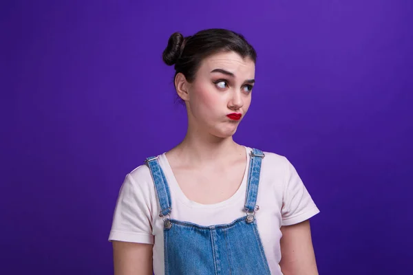 Portrét dívky přemýšlí o něčem na purpurovém pozadí — Stock fotografie