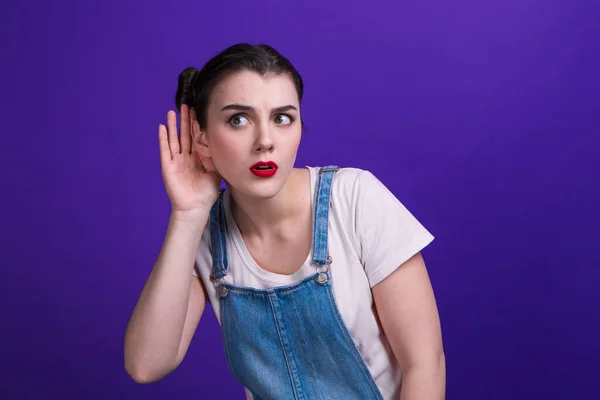 Vrouw houdt hand in hand oor proberen te luisteren naar interessant nieuws uiten communicatie concept en roddel geïsoleerd over paarse achtergrond. — Stockfoto