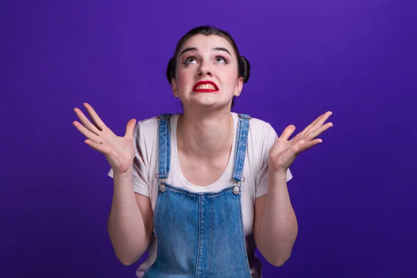 Portrait of annoyed angry woman holding hands in furious gesture over purple background. — ストック写真