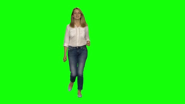 Mujer rubia está corriendo y luego se detuvo en la pantalla verde. Tecla de croma, tiro de 4k. Vista frontal . — Vídeos de Stock