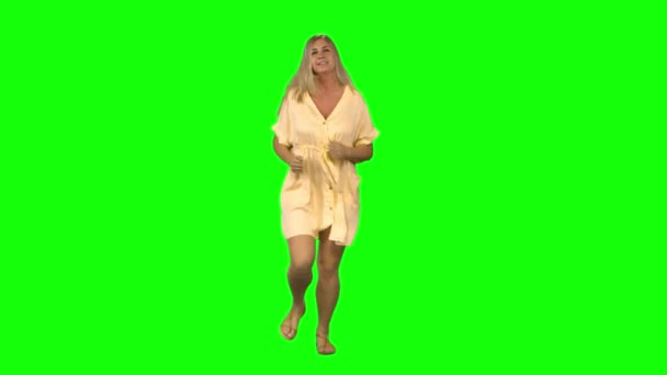 Den garvade blonda kvinnan springer, vinkar och stannar sedan på grön skärm. Framifrån. — Stockvideo