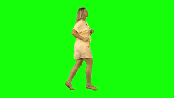 Tanned blond woman is running with smile on green screen. Profile view. — Stock Video