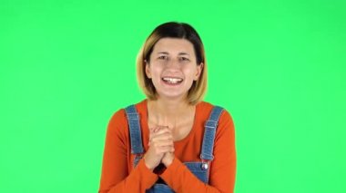 Sevimli bir kadın heyecanla kameraya bakıyor, sonra da zafer zaferini kutluyor. Yeşil Ekran