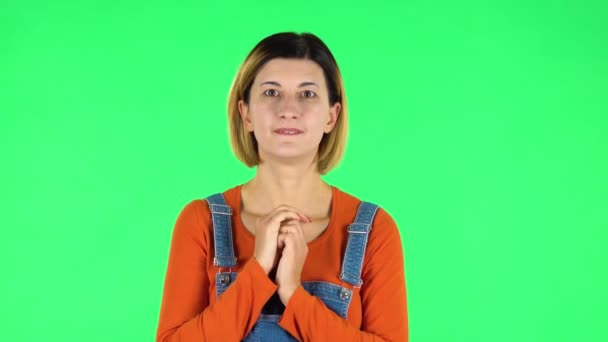 Vrouw staat verontrustend in verwachting dan glimlacht met opluchting, gedragen. Groen scherm — Stockvideo