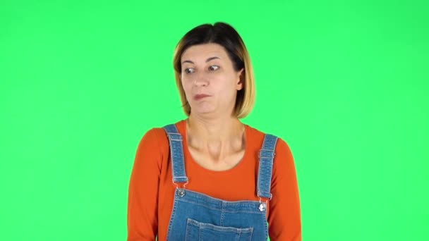 Woman disappointed looks in camera bites her lip then shrugs. Green screen — Stock Video