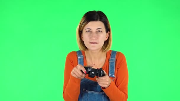 Girl playing a video game using a wireless controller with joy and rejoicing in victory. Green screen — Stock Video