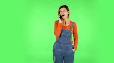 Cep telefonu için konuşan bir kız, çok şaşırır ve sevinir. Yeşil Ekran