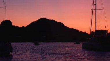 Akdeniz, Lipari Adaları 'nda demirli yelkenli teknelerinde yüzen yatın görüntüsü. Gün batımı, renkli gökyüzü. Sicilya, İtalya