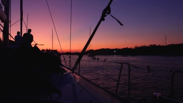 Pohled z plovoucí jachty s lidmi na palubě na zakotvených plachetnic ve Středozemním moři, Liparské ostrovy. Západ slunce, barevná obloha. Sicílie, Itálie — Stock video