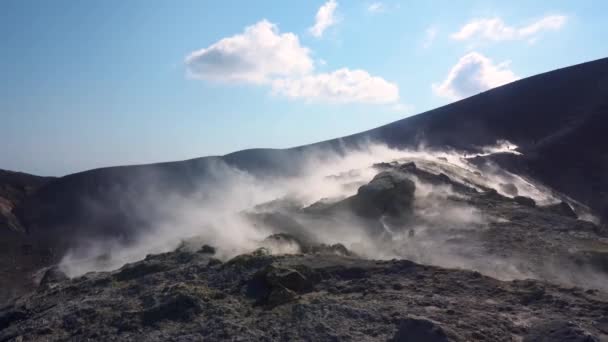 A vulkán szigetén füstölgő forró vulkáni gáz távozik. A vulkán gőzölgő felszíne. Kék ég. Lipari szigetek. Szicília, Olaszország. Közelről. — Stock videók