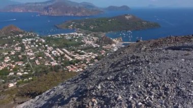 Akdeniz 'deki Lipari Adaları' ndaki Vulcano adasından görüntü. Binalar, yeşil ağaçlar ve mavi gökyüzü. Yelkenli yatlar ve diğer gemiler. Sicilya, İtalya