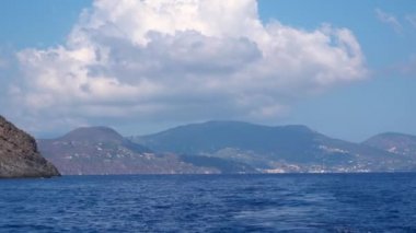 Akdeniz 'deki Lipari Adaları' na bak, Sicilya, İtalya. Yüzen beyaz yelkenli yat. Dağlar, binalar ve mavi gökyüzü